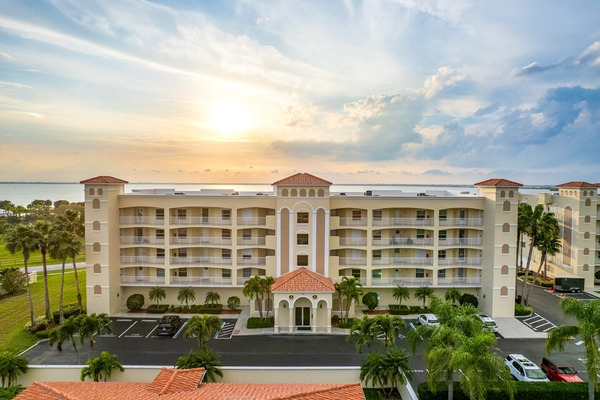 sunrise over a tan condo building with 5 floors