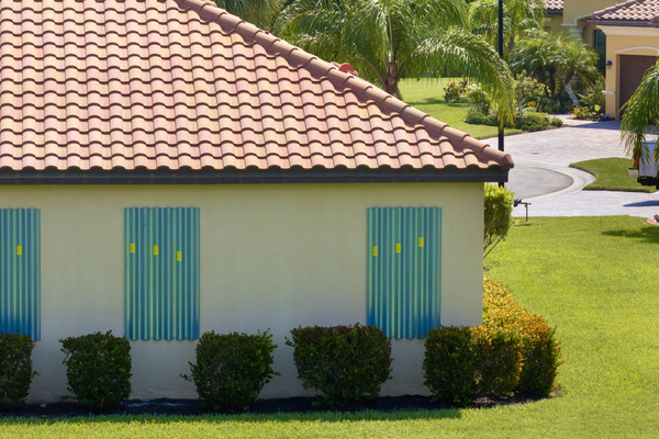 house with brown tile roof and hurricane shutters