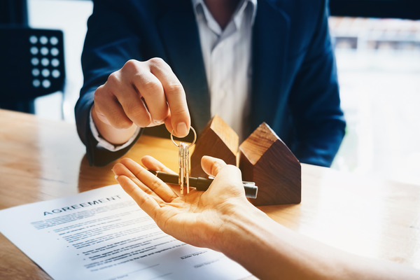 man in suit handing house keys to signer