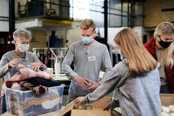 people in health masks sorting donations