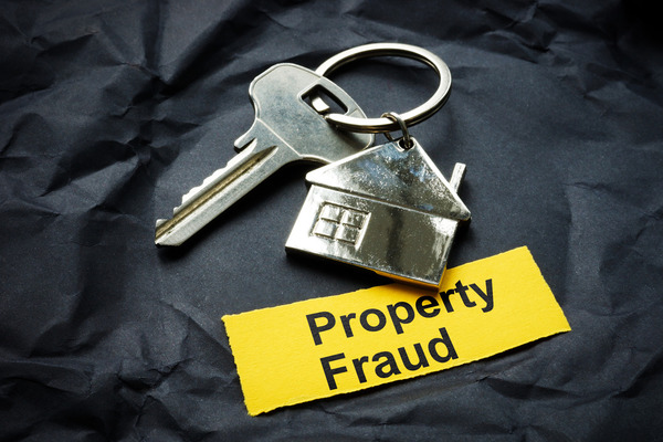 grey background with silver key and property fraud sign