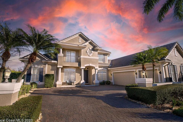 Front view of home from driveway with pink and purple sunset