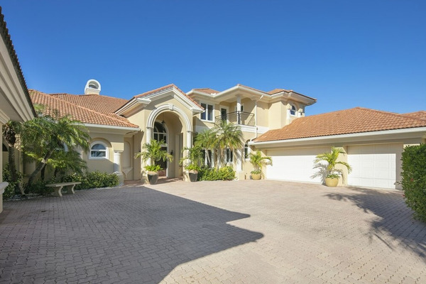 landscaped entryway and three car garage showing upper level