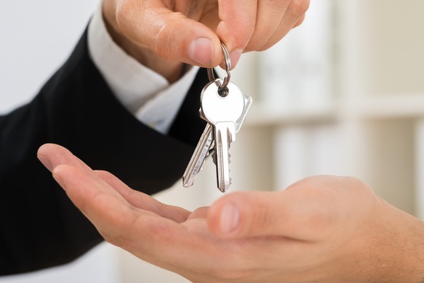 man puts keys into hands of homebuyer