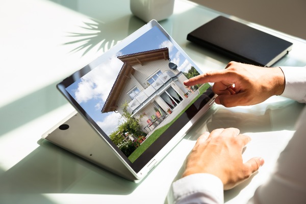 person looking at homes on laptop