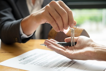woman putting keys in hand over an agreement