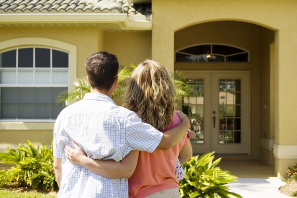 a man and woman holding each other while looking at home