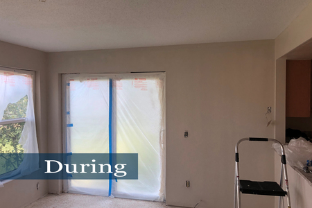 Windows and sliders were covered with plastic in preparation for applying wall texture. Image is of dining area after primer coat was applied