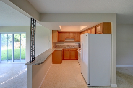 Placing lighting in recessed ceiling and the Terrazzo flooring opens up the space. The new white fridge now coordinates with the stove