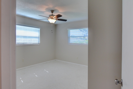 The final image reveals a bright open room with clean lines. A new ceiling fan provides light and cooling for the occupant of bedroom #1.