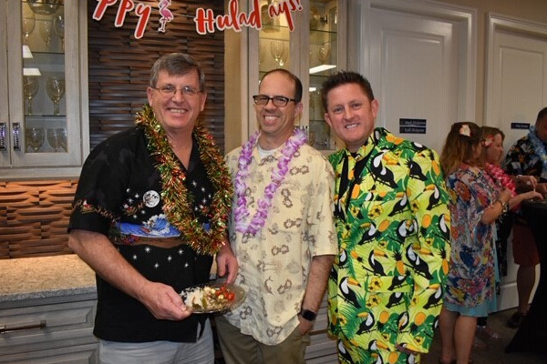 Three members of the Ellingson Properties team in their best tropical outfits