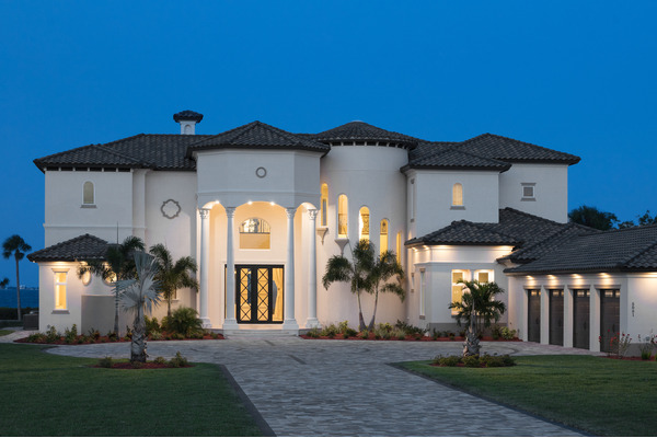 Twilight illuminates circular driveway, 4 car side entry garage & 2 story home