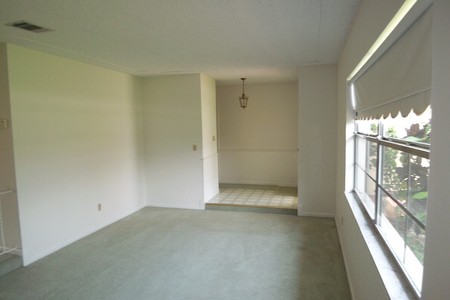 Before - Tile entry to carpeted living room and older roller blinds made the space choppy, dated and small