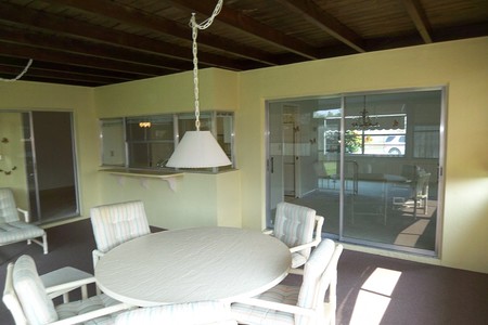 Before - Enclosed Florida Room is dated due to older light fixtures,  yellow wall paint and indoor outdoor carpet