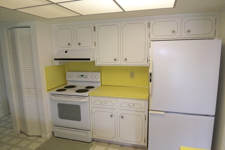 Before - Kitchen had low ceiling, dated appliances and bright yellow Formica.