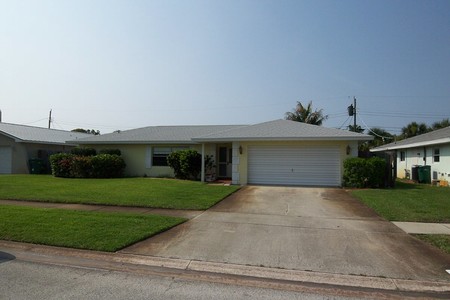 Before - Stained driveway and yellow exterior provides a hint of what lies inside