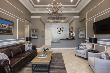 Elegant waiting room and reception area features multi-tier tray ceiling, crown molding, sofa chair seating as well as TV.