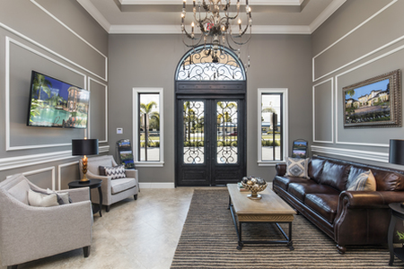 View from the reception desk of the dramatic double door iron and glass entry with side light windows and arched transom. 