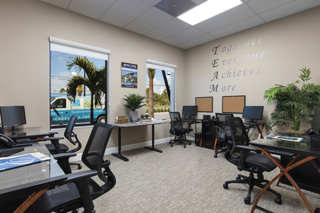 A second agent bullpen with seating for six and inspirational TEAM statement on wall.