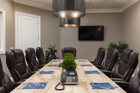 Ellingson Properties Board Room with custom stone table features monitors on either end and is lent to non-profits for offsite meeting use.
