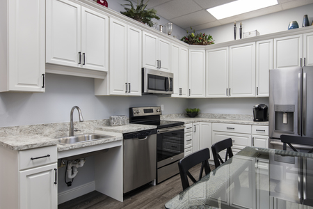 Fully equipped kitchen is used daily and boasts white cabinetry, refrigerator, stove and dishwasher. Wood look vinyl flooring stands up to the high foot traffic!