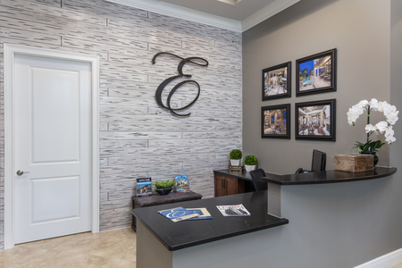 Reception area features hand painted distressed beach wood wall displaying metal Ellingson E. 2 tier counter of leather finish granite is ADA compliant.
