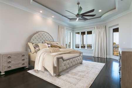 Second master bedroom features back lit bronze tray ceiling with crown molding detail and balcony access.
