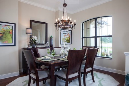 Formal dining room features tray ceiling and warm wood flooring