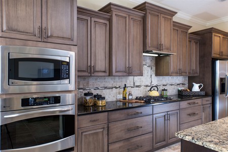 The gas cooktop is flanked by the refrigerator and built-in oven/microwave.  