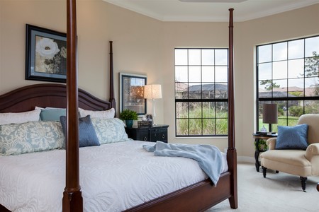 A large master suite with bay windows overlooking the preserve