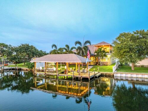 Private covered boat dock on canal at back of home